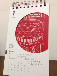 a calendar with an image of a red building on it's front and side