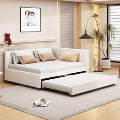 a living room with a white couch, ottoman and coffee table on the floor in front of it