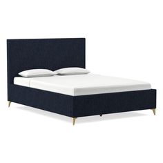 an image of a bed with blue upholstered headboard and white pillows on it