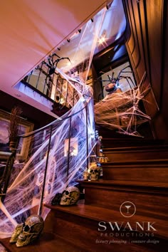 the staircase is decorated with spider webs and skulls