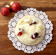 a cookie sitting on top of a white doily next to two red strawberries