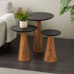 three wooden tables sitting on top of a hard wood floor next to a white couch