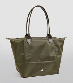 Drawing you in with its generous size and logo detailing, Longchamp’s sustainably crafted Le Pliage Green shoulder bag promises to cement its place in your accessories collection when you discover its packaway structure. Aptly named after the French verb meaning ‘to fold’, the lightweight design utilises origami inspirations to neatly fold into a compact shape when it’s not in use. Longchamp Le Pliage Green, Green Shoulder Bag, French Verbs, Green Tote Bag, Green Tote, Accessories Collection, Winter Essentials, Longchamp Le Pliage, Green Bag