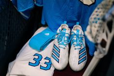 a pair of blue and white shoes sitting on top of a baseball uniform