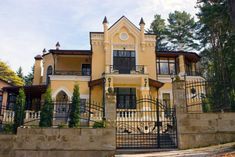 a large yellow house with wrought iron gates