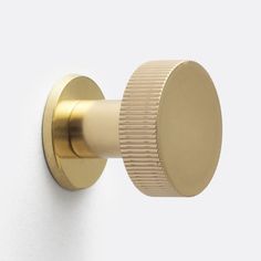 a close up of a door knob on a white wall with a gold colored handle