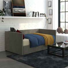 a living room with a couch, coffee table and bookshelf on the wall