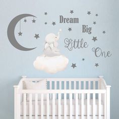 a baby's room with a crib and wall decal that says dream big little one