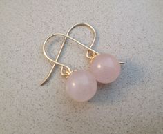 Delicate and tasteful pair of natural Rose Quartz earrings. Each earring is made of a round smooth bead of natural Rose Quartz and a Gold Deeped setting. Each bead is 8.00mm in diameter. If you prefer, we can also prepare these earrings with smaller beads, size 6.00mm. Material: Gold Filled For more earrings: http://etsy.me/2ru2olL Elegant Nickel-free Rose Quartz Earrings, Rose Quartz Ear Wire Earrings For Gift, Rose Quartz Earrings With Ear Wire As Gift, Rose Gold Earrings With Round Beads For Gift, Gem Stone Earrings, Romantic Gifts For Wife, Bracelets Ideas, Gemstone Earrings Gold, Horse Necklace