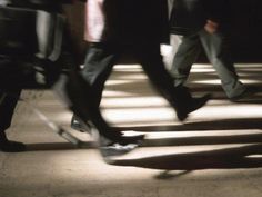 several people are walking down the street on their skateboards