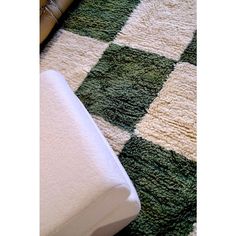 a green and white checkered rug on the floor