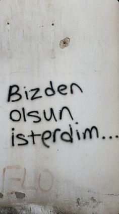 graffiti written on the side of a white wall with black writing that reads bizden osun istterdin