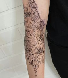 a woman with a tattoo on her arm has a black and white flower design on it