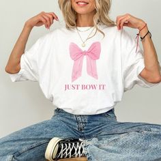 Elevate your wardrobe with our "Just Bow It"- a perfect blend of preppy charm and modern style. This trendy graphic tee is designed to celebrate femininity and add a touch of elegance to your everyday look. *Trackable shipping: Delivery with tracking within 2-5 business days (after processing time) *High-quality: Crafted with care and attention to detail This is a comfort colors T-shirt. Unisex adult sizing. Props used in photos are not included with the purchase. Washing instructions Machine wash cold, inside-out, gentle cycle with mild detergent and similar colors. Use non-chlorine bleach only when necessary--no fabric softeners. Tumble dry low or hang dry for the most extended life. Cool iron inside-out if necessary. Do not iron decoration. Do not dry clean. Sizing For a more fitted loo Bow Shirts Women, Preppy Cotton T-shirt With Letter Print, Preppy Cotton Tops With Graphic Print, Preppy Cotton Top With Graphic Print, Preppy White T-shirt For Spring, White Cotton Preppy T-shirt, Preppy Short Sleeve T-shirt For Spring, Preppy Crew Neck Top With Graphic Print, Preppy Cotton Tops With Letter Print