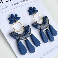 two pairs of blue earrings on top of a magazine