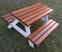 a wooden picnic table sitting in the grass