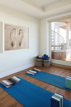 there are many mats on the floor in this room with yoga mats and towels around them