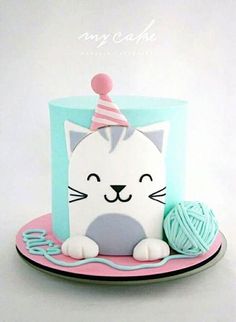 a cat cake with a ball of yarn on the top and a birthday hat on top