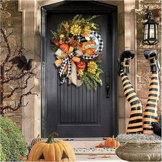 a front door decorated for halloween with pumpkins and sunflowers