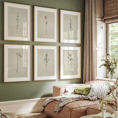 a living room with green walls and pictures on the wall above the couch in front of it