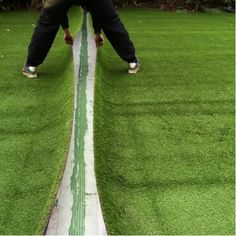 a man standing on top of a green grass covered field next to a white line