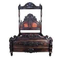 an antique wooden bed with ornate carvings on the headboard and foot board, against a white background