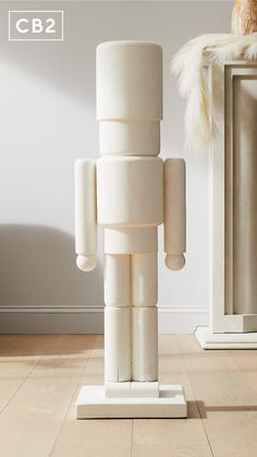 a white toy standing on top of a wooden floor