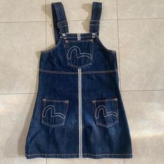 Evisu Extremely Rare Dead Stock Overalls Dark Blue Denim Dress/Skirt With 3 Pockets With Famous Logo In White Stitching (One In Middle) Two On The Thighs. Has Side Zipper, Logo On Back With Pink And Red Detailing. Size Medium. Length Is Approximately 26.5”. Evisu Jeans, Blue Denim Dress, Famous Logos, Denim Overall Dress, Jean Overalls, Dark Blue Denim, Pink And Red, Overall Dress, Medium Length