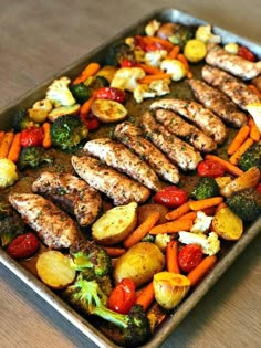 a pan filled with chicken, vegetables and broccoli