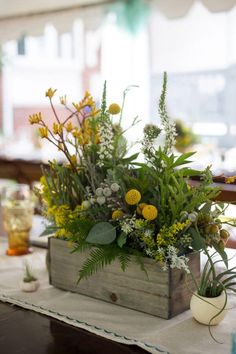 a wooden box filled with flowers on top of a table