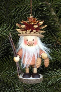 a christmas ornament hanging on a tree with a fishing rod and pine cone