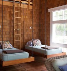 two beds in a room with wood paneling and glass partitions to the wall