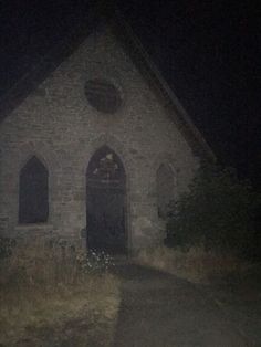 an old stone church at night with the light on