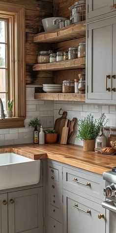 a kitchen filled with lots of counter top space and wooden shelves next to a window