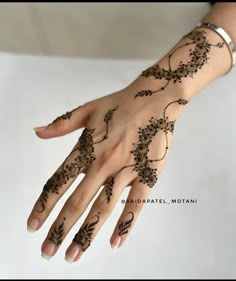 a woman's hand with henna tattoos on it