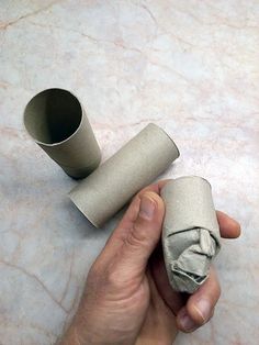 a person holding two rolls of toilet paper