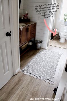 a bathroom with white walls and wood floors