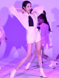 a group of young women standing on top of a dance floor in front of a purple background