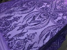 a purple table cloth with silver sequins on it and an intricate design in the center