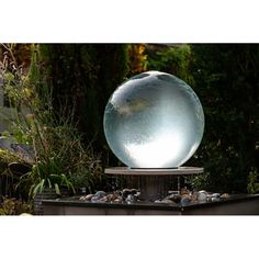 a large glass ball sitting on top of a fountain