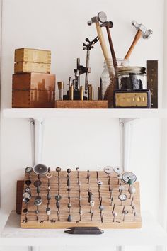 two shelves with various items on top of each other in front of a white wall