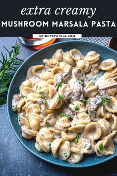 a blue plate topped with pasta covered in mushroom sauce and garnished with parsley