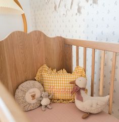 a crib with stuffed animals and pillows in it