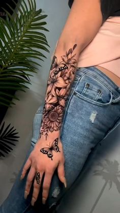 a woman's arm with flowers and butterflies on it