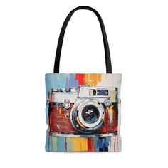 "Introducing our Abstract Camera Art Tote Bag, a creative fusion of the everyday with the extraordinary. A depiction of a camera designed with a vibrant palette knife technique, its red, yellow, and blue hues appear as if they're made from liquid metal, creating a color splash that commands attention. This tote bag is more than a convenient accessory; it's an extension of your artistic passion. An abstract interpretation of a camera makes this tote a standout piece, while a blend of post-impressionism and precision painting techniques provides a stunning visual appeal. Whether you're an art enthusiast, a professional photographer, or a lover of unique style, this tote bag will serve as a beautiful addition to your collection. Thank you for supporting our small business! Please, do not hesi Camera Art, Liquid Metal, Art Tote Bag, Palette Knife, Soft Bristle Brush, Silk Painting, Blue Hues, Color Splash, Gifts For Her