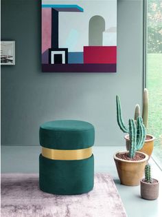 a living room with a cactus, potted plants and a painting on the wall