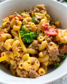 a white bowl filled with pasta and meat