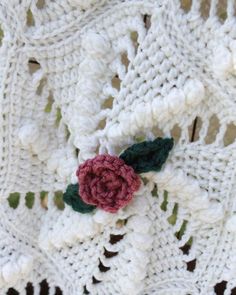 a crocheted blanket with a flower on it