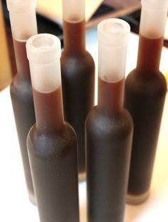 six brown bottles with white caps sitting on a table