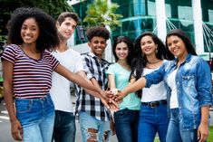 a group of young people holding hands in front of a building